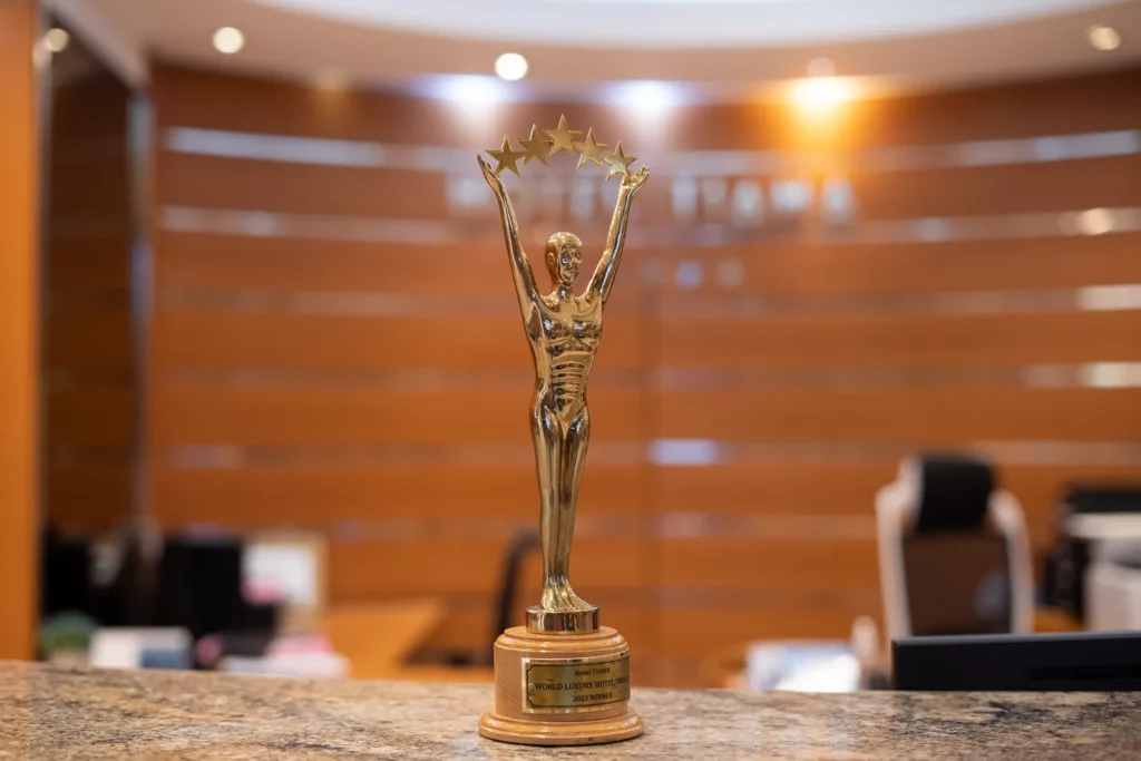 Trophée de l'Hôtel TIAMA devant le mur de la réception
