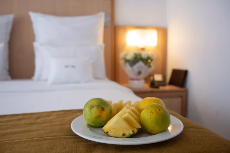 Assiette de fruits frais de bienvenue posée sur le lit