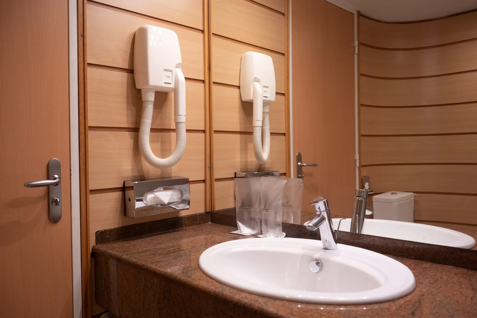 Salle de bain avec sèche-cheveux et plan de vasque en granit