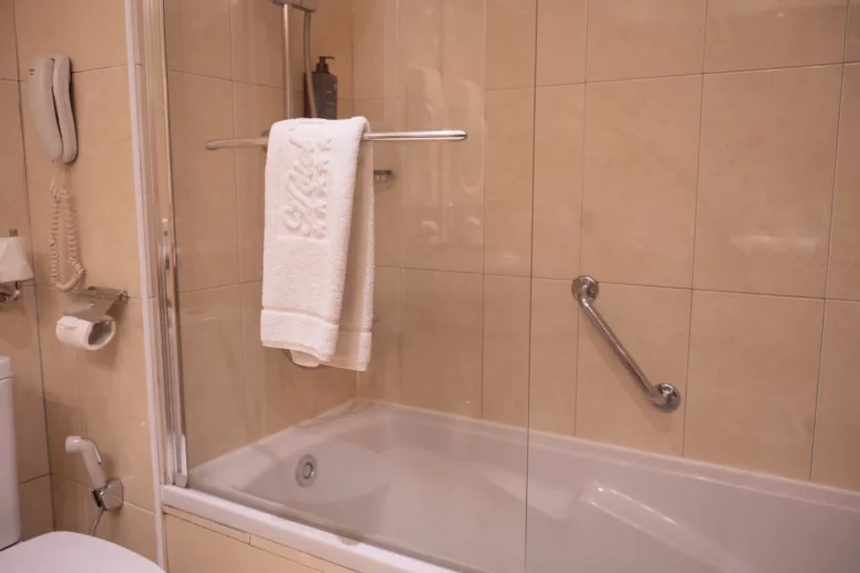 Baignoire avec pare-douche et serviettes