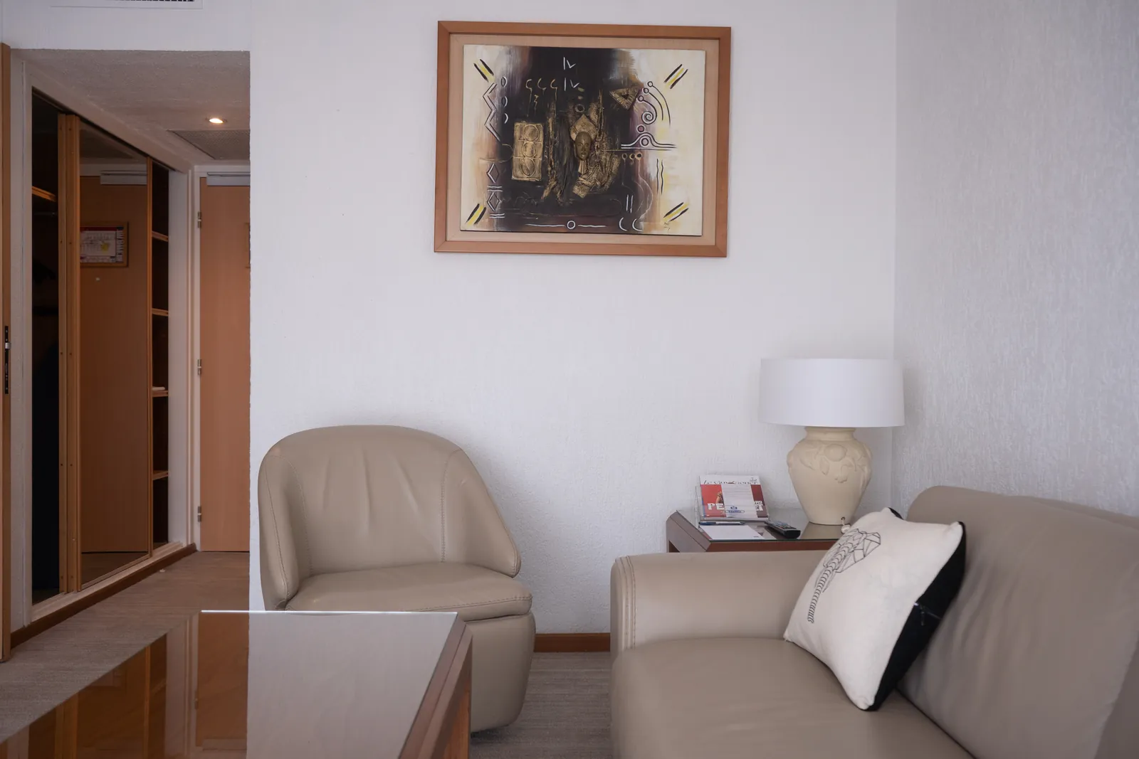 Espace salon de la Suite Junior avec fauteuil et lampe