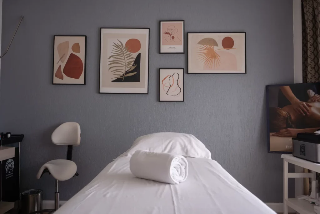 Cabine de soins avec table de massage et tableaux